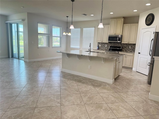 5082 Inshore Landings Dr, Apollo Beach, FL 33572 - kitchen featuring stainless steel appliances, decorative backsplash, light stone countertops, light tile patterned floors, and recessed lighting