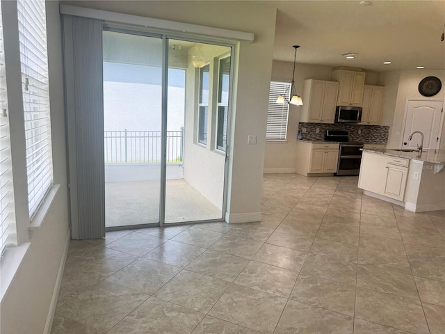 5082 Inshore Landings Dr, Apollo Beach, FL 33572 - kitchen with appliances with stainless steel finishes, plenty of natural light, backsplash, recessed lighting, and hanging light fixtures