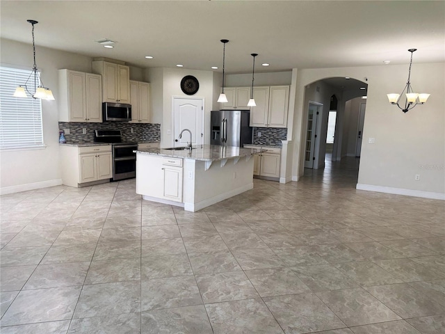 5082 Inshore Landings Dr, Apollo Beach, FL 33572 - kitchen featuring appliances with stainless steel finishes, backsplash, arched walkways, recessed lighting, and light stone counters