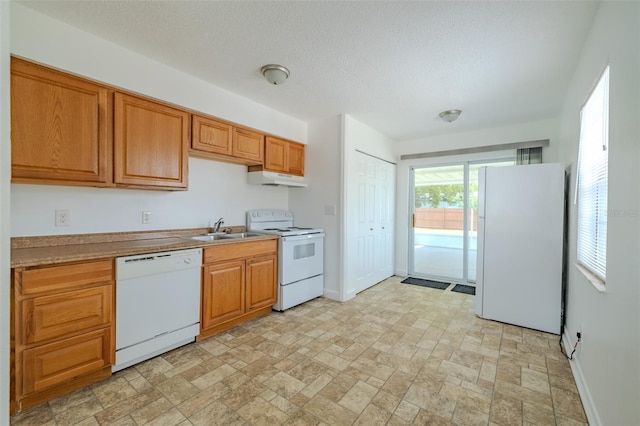 932 W Wheeler Rd, Brandon, FL 33510 - kitchen with white appliances, under cabinet range hood, brown cabinets, a textured ceiling, and stone finish flooring