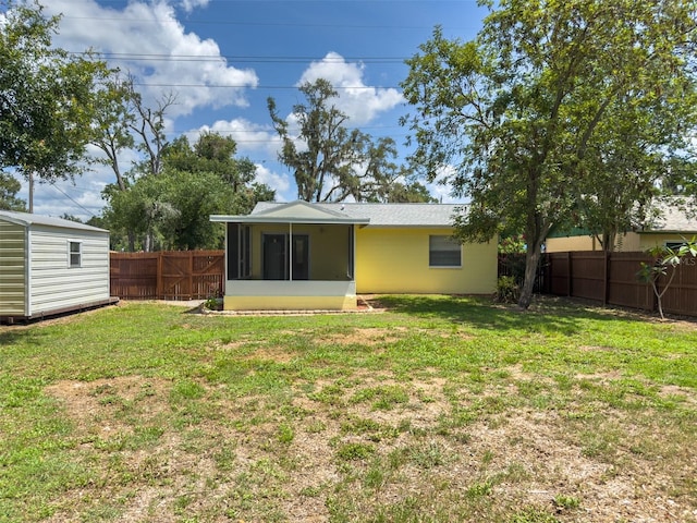 932 W Wheeler Rd, Brandon, FL 33510 - rear view of property with a sunroom, a fenced backyard, and a storage shed