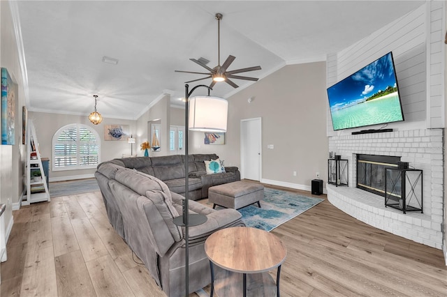 832 Birdie Way, Apollo Beach, FL 33572 - living area featuring light wood-type flooring, vaulted ceiling, a fireplace, a ceiling fan, and crown molding