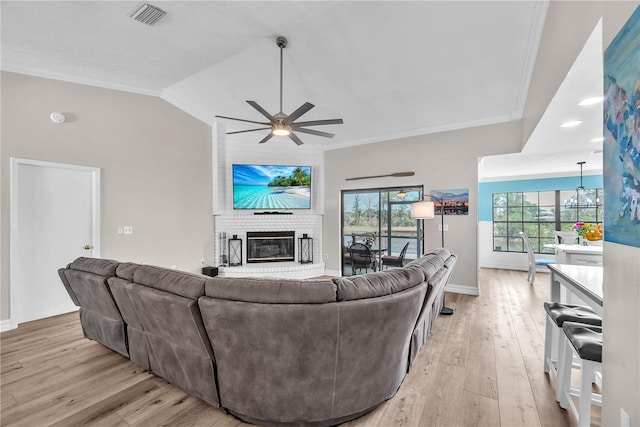832 Birdie Way, Apollo Beach, FL 33572 - living area featuring a fireplace, a ceiling fan, crown molding, light wood-style flooring, and vaulted ceiling