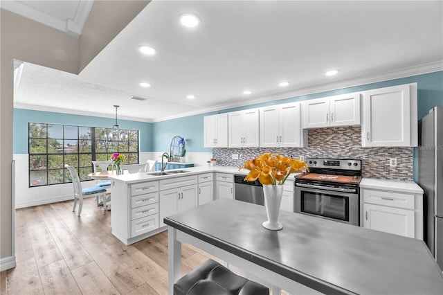832 Birdie Way, Apollo Beach, FL 33572 - kitchen with appliances with stainless steel finishes, a peninsula, ornamental molding, white cabinets, and light countertops