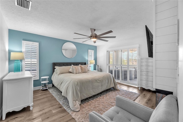 832 Birdie Way, Apollo Beach, FL 33572 - bedroom with access to outside, wood finished floors, a ceiling fan, and a textured ceiling