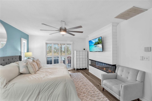 832 Birdie Way, Apollo Beach, FL 33572 - bedroom with wood finished floors, a large fireplace, and a ceiling fan