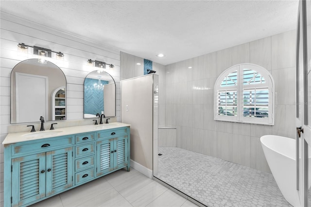 832 Birdie Way, Apollo Beach, FL 33572 - bathroom with a walk in shower, double vanity, a freestanding tub, a textured ceiling, and tile patterned floors