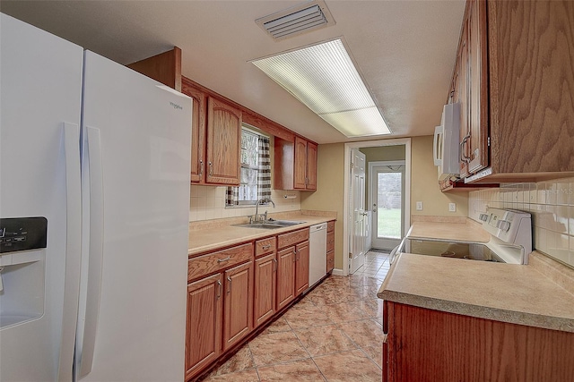 14047 Briardale Ln, Tampa, FL 33618 - kitchen featuring white appliances, decorative backsplash, brown cabinets, and light countertops