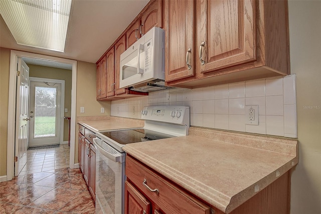 14047 Briardale Ln, Tampa, FL 33618 - kitchen with white appliances, decorative backsplash, light countertops, and light tile patterned flooring