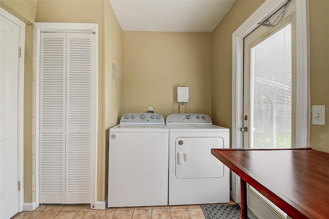 14047 Briardale Ln, Tampa, FL 33618 - washroom with washing machine and clothes dryer, light tile patterned flooring, and a textured ceiling