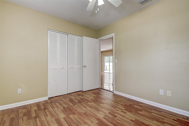 14047 Briardale Ln, Tampa, FL 33618 - unfurnished bedroom with wood finished floors, a closet, a textured ceiling, and ceiling fan