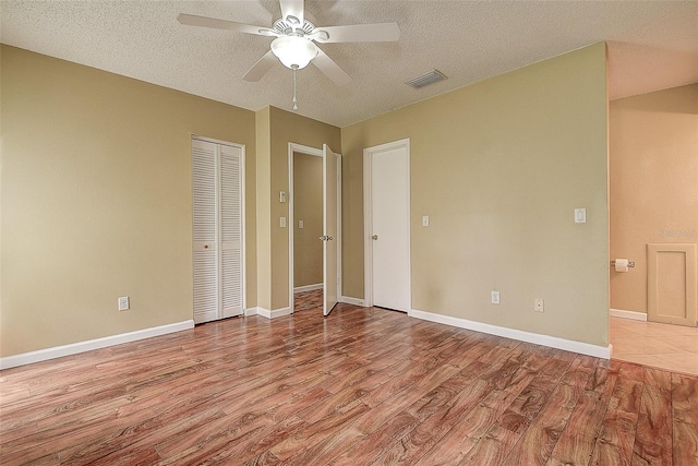 14047 Briardale Ln, Tampa, FL 33618 - unfurnished bedroom with wood finished floors, a textured ceiling, ceiling fan, and a closet