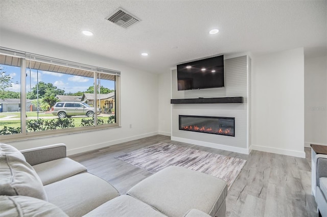 4228 Belle Isle Ct, New Port Richey, FL 34653 - living area featuring a fireplace, recessed lighting, a textured ceiling, and wood finished floors