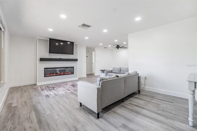 4228 Belle Isle Ct, New Port Richey, FL 34653 - living area with wood finished floors, a fireplace, recessed lighting, and ceiling fan