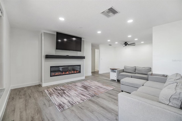 4228 Belle Isle Ct, New Port Richey, FL 34653 - living area with recessed lighting, a fireplace, ceiling fan, and wood finished floors