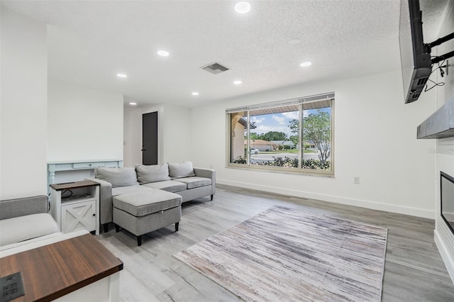 4228 Belle Isle Ct, New Port Richey, FL 34653 - living room with recessed lighting, light wood finished floors, and a textured ceiling