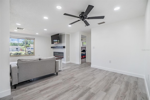 4228 Belle Isle Ct, New Port Richey, FL 34653 - living room with recessed lighting, light wood-type flooring, ceiling fan, and a fireplace