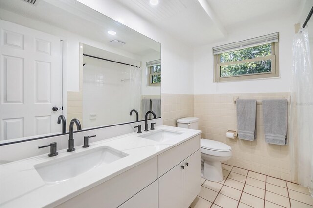 4228 Belle Isle Ct, New Port Richey, FL 34653 - bathroom with tile walls, tile patterned flooring, double vanity, a shower with curtain, and wainscoting