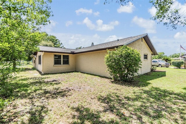 4228 Belle Isle Ct, New Port Richey, FL 34653 - back of house featuring stucco siding and a yard