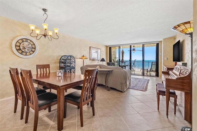 1290 Gulf Blvd Unit 702, Clearwater Beach, FL 33767 - dining area featuring a chandelier, a wall of windows, a textured ceiling, and light tile patterned flooring