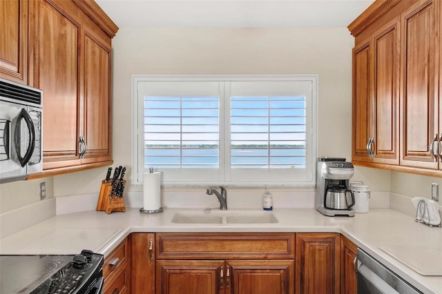 1290 Gulf Blvd Unit 702, Clearwater Beach, FL 33767 - kitchen with brown cabinetry, appliances with stainless steel finishes, and light countertops