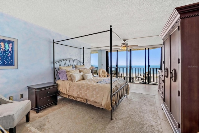 1290 Gulf Blvd Unit 702, Clearwater Beach, FL 33767 - bedroom with a textured ceiling, access to outside, a water view, light tile patterned flooring, and multiple windows