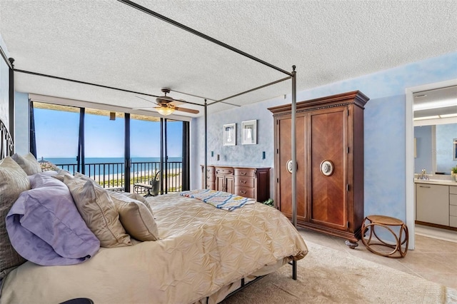 1290 Gulf Blvd Unit 702, Clearwater Beach, FL 33767 - bedroom with access to exterior, a textured ceiling, a water view, light tile patterned floors, and connected bathroom