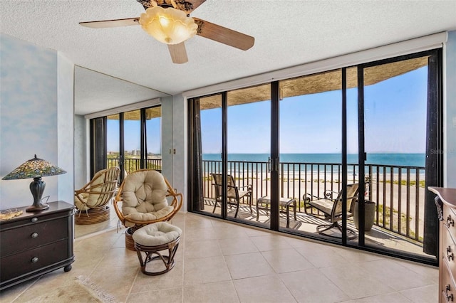 1290 Gulf Blvd Unit 702, Clearwater Beach, FL 33767 - sunroom featuring view of water and beach, a textured ceiling, tile patterned flooring, and a wall of windows