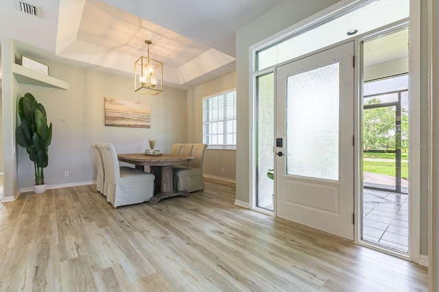 7725 235th St E, Myakka City, FL 34251 - dining space featuring light wood-style floors, a chandelier, and a raised ceiling