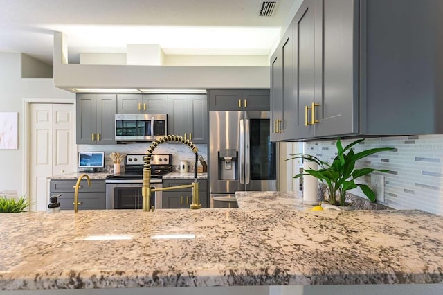 7725 235th St E, Myakka City, FL 34251 - kitchen featuring appliances with stainless steel finishes, backsplash, and light stone counters