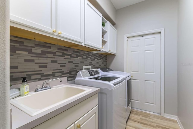7725 235th St E, Myakka City, FL 34251 - laundry room with washing machine and clothes dryer, cabinet space, and light wood-style floors