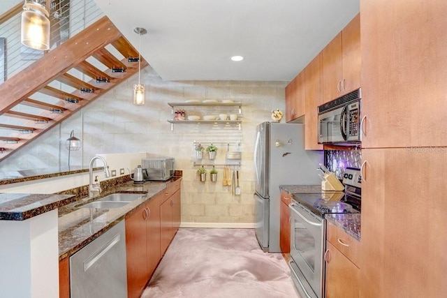 2001 E 2nd Ave Unit 37, Tampa, FL 33605 - kitchen with appliances with stainless steel finishes, dark stone countertops, brown cabinetry, and hanging light fixtures