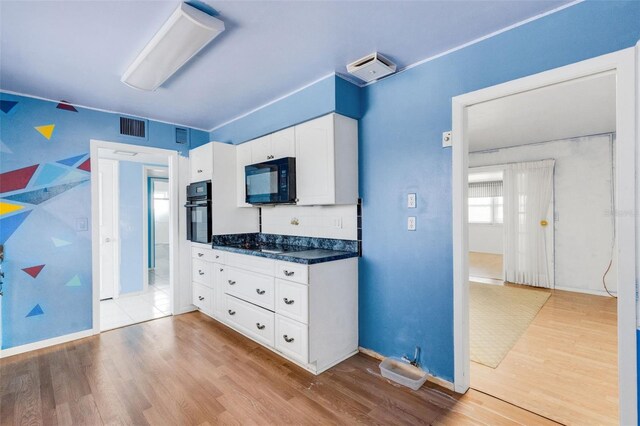 638 La Jolla Ave, Sun City Center, FL 33573 - kitchen featuring black appliances, dark countertops, wood finished floors, and white cabinets