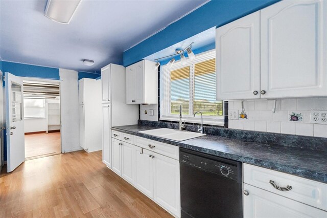 638 La Jolla Ave, Sun City Center, FL 33573 - kitchen featuring black dishwasher, dark countertops, light wood-style floors, and white cabinetry