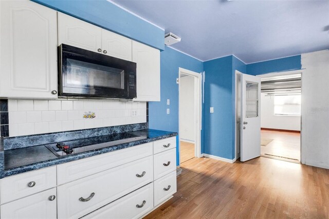 638 La Jolla Ave, Sun City Center, FL 33573 - kitchen featuring black appliances, dark countertops, light wood-style floors, tasteful backsplash, and white cabinets