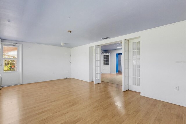 638 La Jolla Ave, Sun City Center, FL 33573 - spare room with light wood-style flooring, french doors, and a pendent fire sprinkler