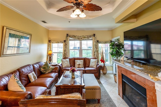 2724 Via Murano Unit 639, Clearwater, FL 33764 - living room featuring ornamental molding, ceiling fan, a high end fireplace, light tile patterned floors, and a tray ceiling