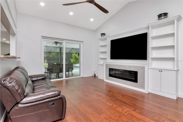 18004 Clear Lake Dr, Lutz, FL 33548 - living room with a ceiling fan, lofted ceiling, wood finished floors, recessed lighting, and a glass covered fireplace