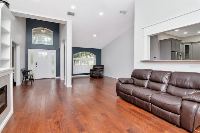 18004 Clear Lake Dr, Lutz, FL 33548 - living room featuring dark wood-style floors, high vaulted ceiling, a glass covered fireplace, and recessed lighting