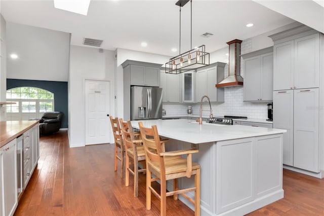 18004 Clear Lake Dr, Lutz, FL 33548 - kitchen featuring stainless steel fridge with ice dispenser, gray cabinets, wall chimney exhaust hood, backsplash, and dark wood-style flooring
