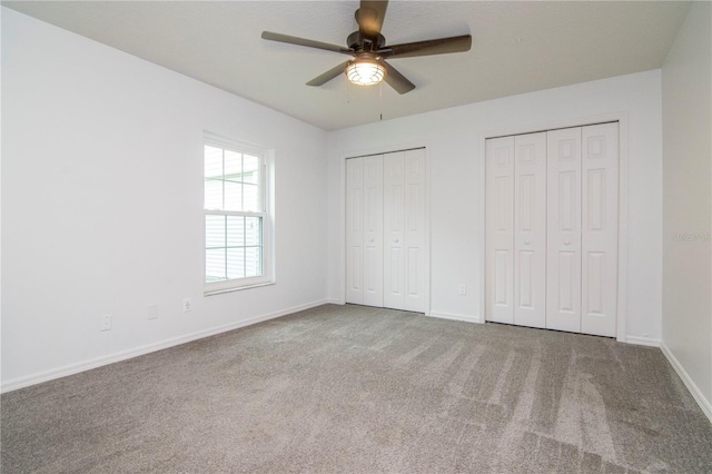 18004 Clear Lake Dr, Lutz, FL 33548 - unfurnished bedroom with two closets, carpet, and ceiling fan