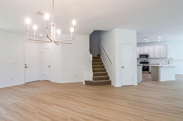 10605 Marsanne Pl, Riverview, FL 33578 - unfurnished living room featuring light wood-style flooring, stairs, a chandelier, and recessed lighting