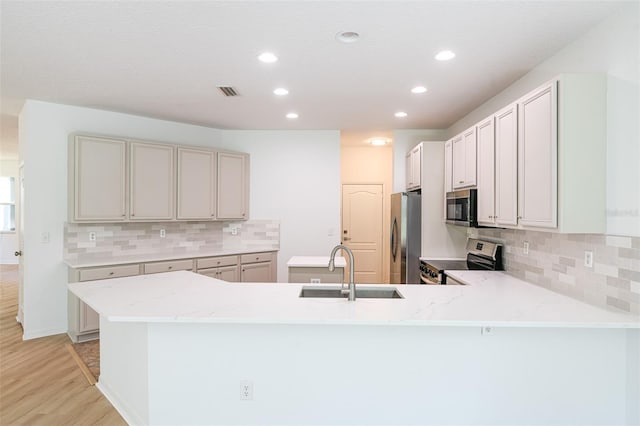 10605 Marsanne Pl, Riverview, FL 33578 - kitchen with stainless steel appliances, light wood-style floors, a peninsula, recessed lighting, and tasteful backsplash