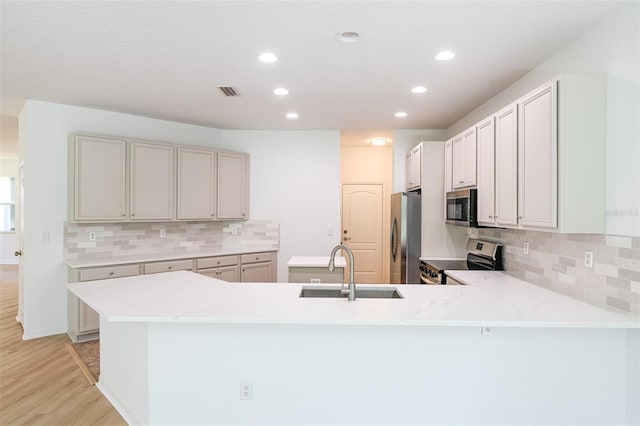 10605 Marsanne Pl, Riverview, FL 33578 - kitchen featuring stainless steel appliances, light wood finished floors, a peninsula, recessed lighting, and tasteful backsplash