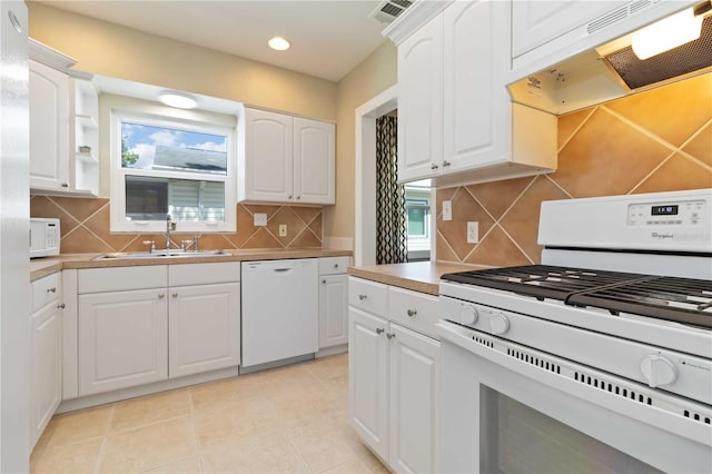 2834 10th Ave N, Saint Petersburg, FL 33713 - kitchen featuring white appliances, under cabinet range hood, decorative backsplash, white cabinetry, and recessed lighting