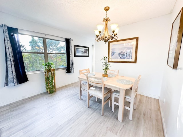2330 Ecuadorian Way Unit 30, Clearwater, FL 33763 - dining room with a chandelier, light wood-style floors, and a textured ceiling