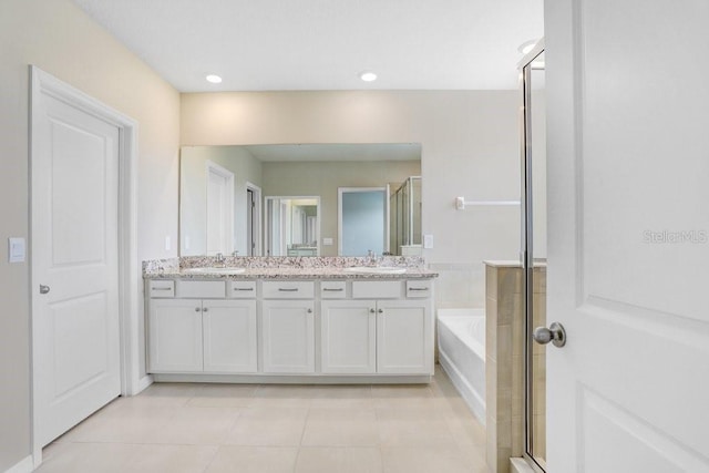 5430 Thistle Field Ct, Wesley Chapel, FL 33545 - full bath featuring double vanity, tile patterned floors, a garden tub, an enclosed shower, and recessed lighting