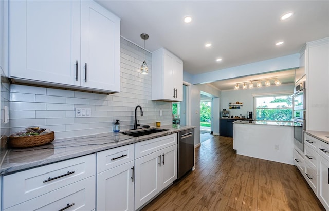 14534 Yacht Club Blvd, Seminole, FL 33776 - kitchen featuring stainless steel appliances, white cabinets, wood finished floors, decorative backsplash, and recessed lighting