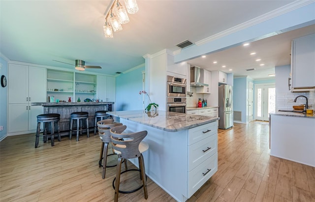 14534 Yacht Club Blvd, Seminole, FL 33776 - kitchen featuring wall chimney exhaust hood, stainless steel appliances, ornamental molding, tasteful backsplash, and white cabinetry