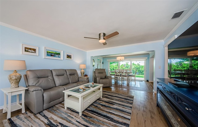 14534 Yacht Club Blvd, Seminole, FL 33776 - living room featuring crown molding, wood finished floors, a ceiling fan, and a chandelier